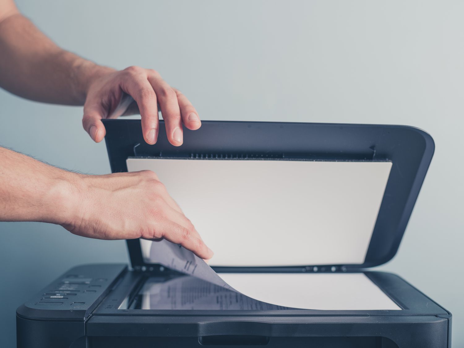 id sjabloon mal beschermde kopie id bewijzen paspoort mallen Een persoon gebruikt een multifunctionele printer: de linkerhand houdt de bovenklep open terwijl de rechterhand een vel papier plaatst op de glasplaat van de scanner, klaar om een document te kopiëren of te scannen